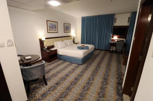 En eller flere senge i et værelse på Larsa Hotel