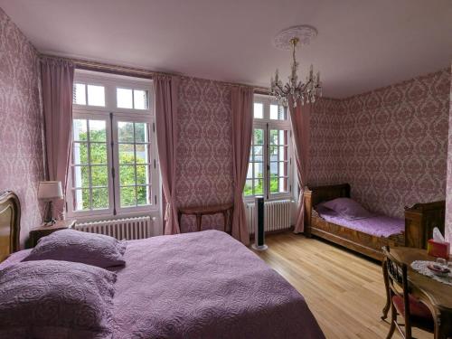 a bedroom with a bed and a table and windows at Castel Saint Laurent in Langeais
