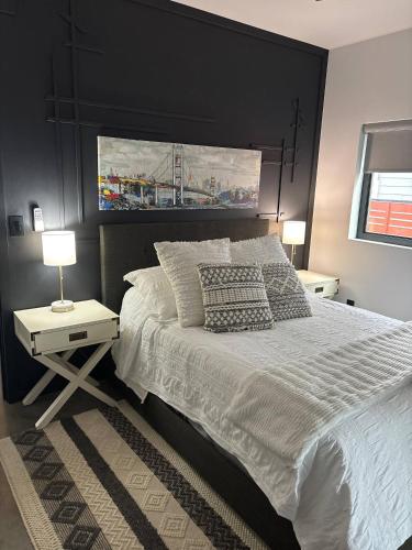 a bedroom with a large bed with a black wall at Exclusive Modern Suite view in Kamloops
