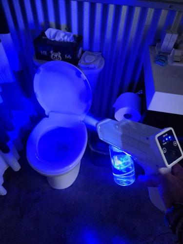 a toilet in a blue room with a remote control at Exclusive Modern Suite view in Kamloops