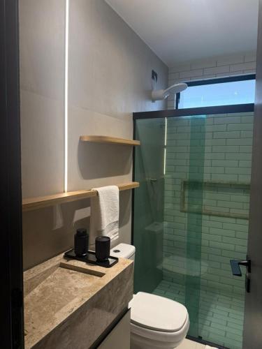 a bathroom with a toilet and a glass shower at FLAT Intermares HUB 105 in Cabedelo