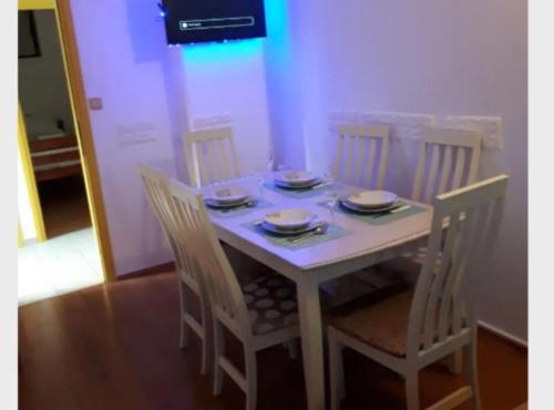 a white table with chairs and plates on it at Apartment Dijana in Bakar