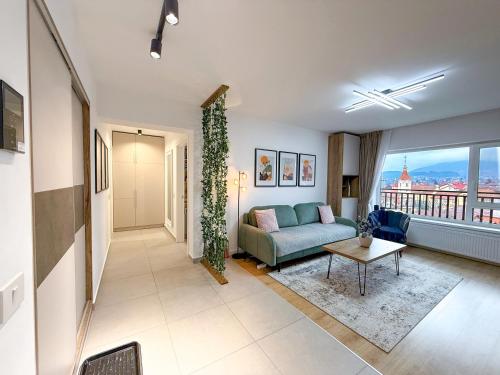 a living room with a couch and a table at Mountain and City View with Underground Parking in Braşov