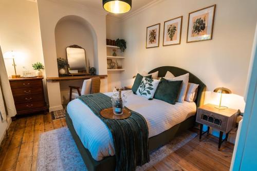 a bedroom with a bed with a table and a mirror at Period apartment in the heart of Bournemouth in Bournemouth