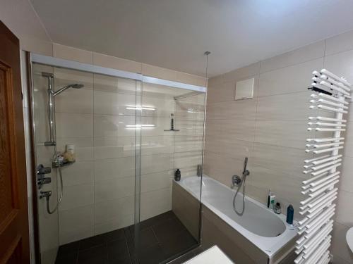 a bathroom with a shower and a bath tub at Ferienhaus Lengau in Saalbach-Hinterglemm
