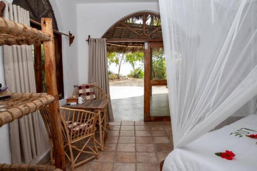 a bedroom with a bed and a door to a patio at VeriDiana Hotel Zanzibar in Dimbani