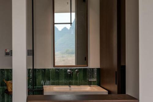a bathroom with a sink and a mirror at Hidden Valley Hotel-- New Hotel,A Hidden Gem,Serene Sanctuary,Exclusive Location,Swimming Pool & Cycling Route,Attraction Tickets Serivce in advance,Affordable Luxury,Best Karst Mount View in Yangshuo in Yangshuo