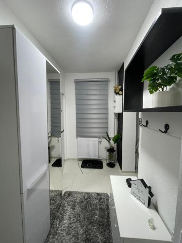 a white room with a desk and a window at Tina apartman in Vranje