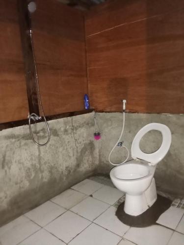 a bathroom with a toilet with a hose connected to it at Nyandetor Homestay in Yennanas Besir