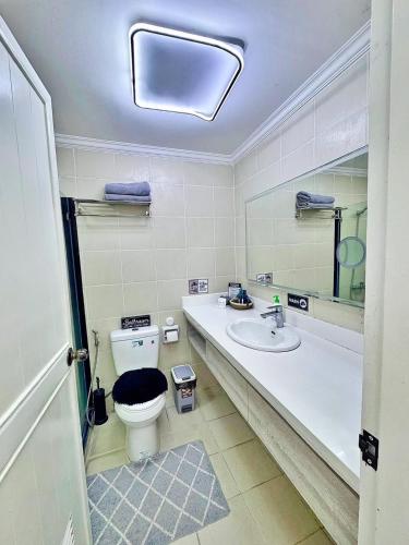a bathroom with a toilet and a sink and a mirror at Club Balai Isabel Front Taal Lake & Volcano View in Talisay