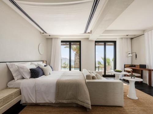 biała sypialnia z dużym łóżkiem i kanapą w obiekcie Anandes Hotel w mieście Mykonos