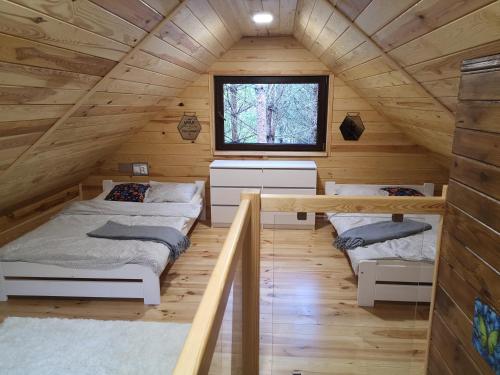 two beds in a room in a log cabin at Domek letniskowy Marksewo Łoś in Marksoby
