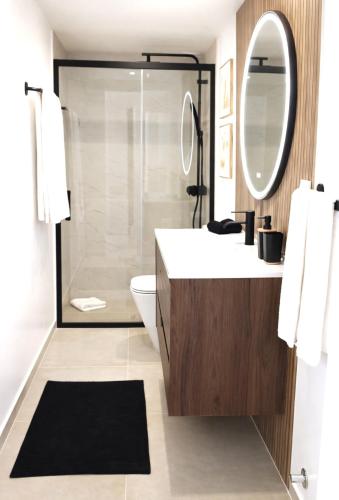 a bathroom with a shower and a sink and a mirror at Casa luz e conforto-Casa 20 in Almancil
