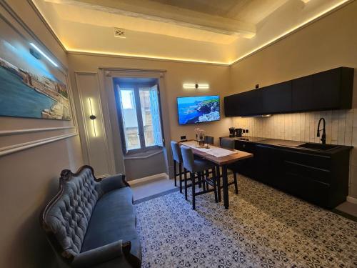 a kitchen with a couch and a table in a room at Portus Noir Valletta in Valletta