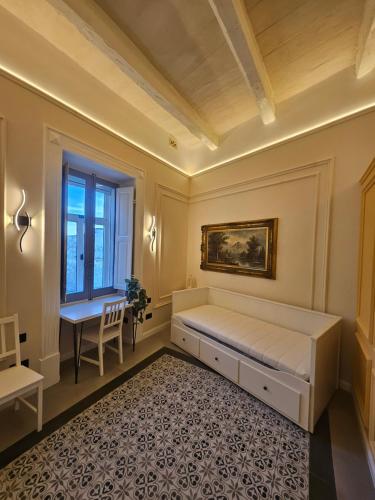 a bedroom with a bed and a desk and a window at Portus Noir Valletta in Valletta