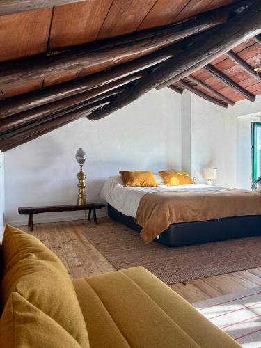a bedroom with a large bed in a attic at Pisco Charming House - Alter Pedroso in Alter do Chão