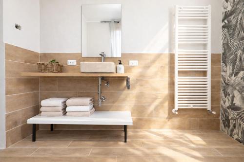 a bathroom with a sink and towels on a bench at Elisir in Bergamo