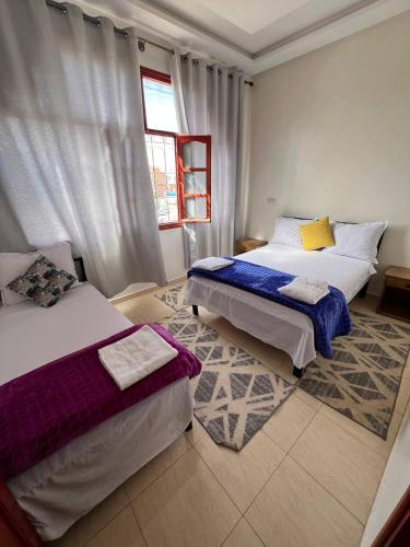 a bedroom with two beds and a window at Hostel dallas Warzazate in Ouarzazate