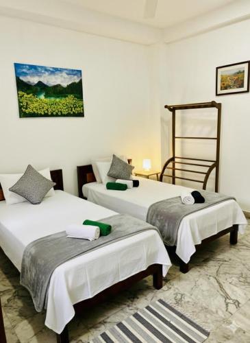two beds in a room with white walls at Villa kresilda in Gampola