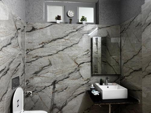 a bathroom with a sink and a marble wall at Maison Royale House 3bhk apartment in Jaipur