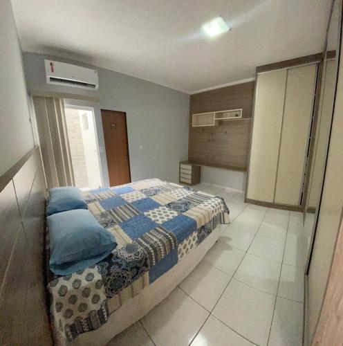 a bedroom with a bed with blue pillows at Casa espaçosa com 3 quartos climatizados in Petrolina