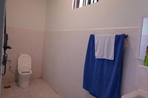 a bathroom with a toilet and a blue towel at Hotel near the clock tower in Arusha