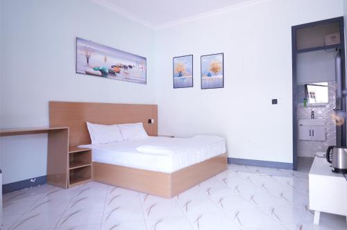 a bedroom with a bed in a white room at Hotel near the clock tower in Arusha