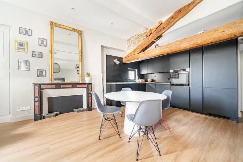 a dining room with a table and chairs and a fireplace at Superbe Appartement Intramuros in Avignon