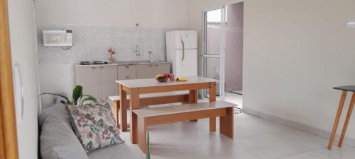 a kitchen with a table and a couch and a refrigerator at Garden House Canastra in Delfinópolis