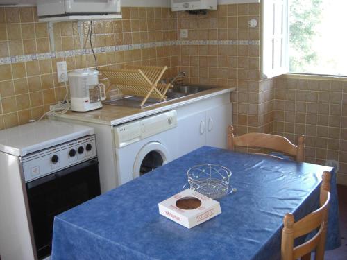 une cuisine avec une table et un chiffon bleu dans l'établissement Guéraçague Etcheverry Garaya, à Saint-Jean-Pied-de-Port