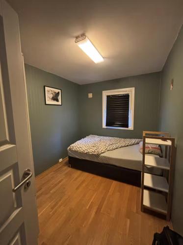 a small bedroom with a bed and a window at Etterstad in Oslo