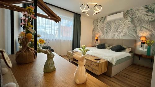 a bedroom with a bed and vases on the floor at Malu Apartman in Sárvár