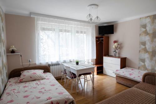 a bedroom with a bed and a table and a window at NOCLEGI Święta Katarzyna CENTRUM in Święta Katarzyna