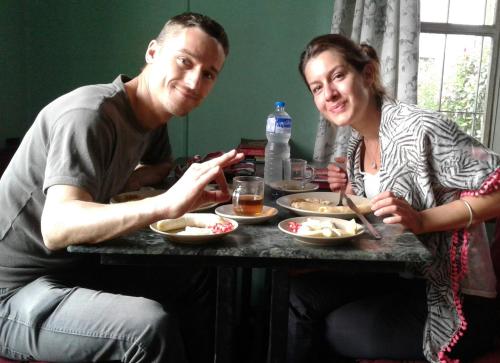 a man and a woman sitting at a table with food at Pradhan House - Home Stay with Garden in Bhaktapur