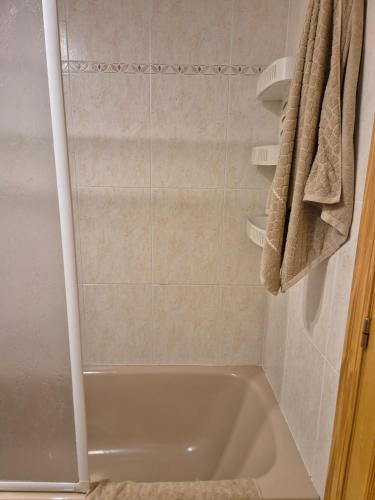 a small bathroom with a tub and a shower at Appartement Stella vue mer in Piles