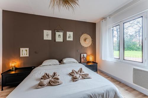 a bedroom with a large bed with towels on it at Le Chalet de la Leyre in Le Teich