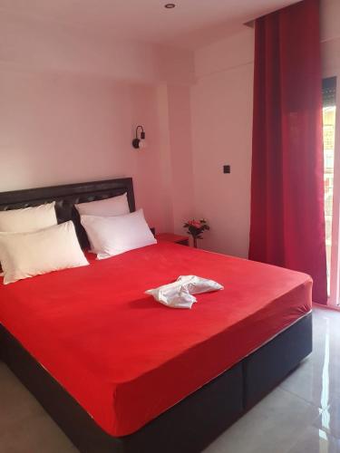 a bedroom with a red bed with two white towels on it at Apartments Vesna Luxury & Stefan Ap 10 in Paralia Katerinis