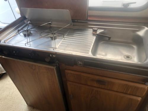 a kitchen with a sink and a stove at Autocaravana in Port Saplaya