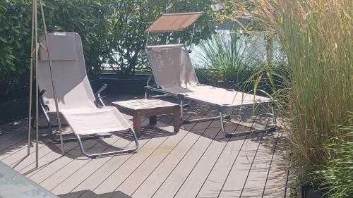 three chairs and a table on a wooden deck at Comfort Rooms mit Whirlpoolzugang in Romanshorn