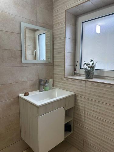 a bathroom with a white sink and a window at Гостьовий двір in Yaremche