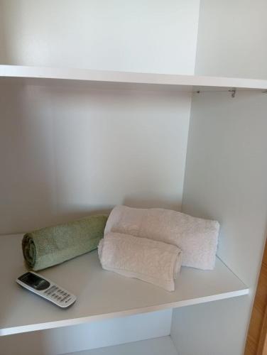 a shelf with two towels and a cell phone on it at Apartment cosy in Sidi Daoud