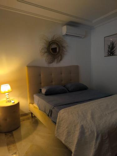 a bedroom with a bed and a lamp next to it at Apartment cosy in Sidi Daoud