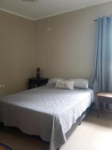 a bedroom with a white bed with blue curtains at Kactus de la abuela in Yerba Buena