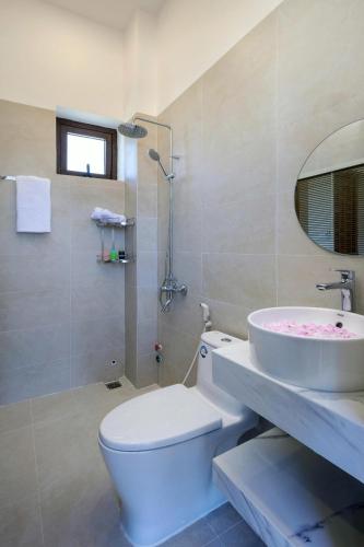 a bathroom with a white toilet and a sink at Homestay Hòn Đỏ Sea in Thôn Mỹ Tường