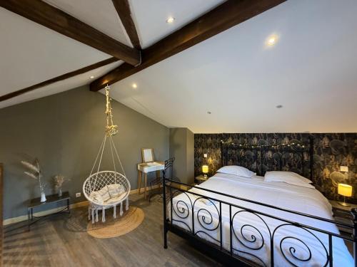 a bedroom with a large bed and a swing at La Maison cachée du PAVILLON BELLEVUE in Belley
