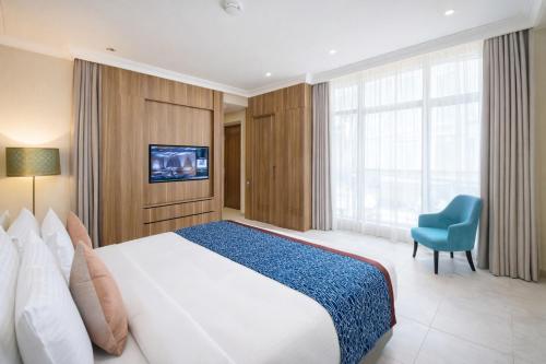 a bedroom with a large bed and a blue chair at Tilal Jabal Al Kabah in Mecca