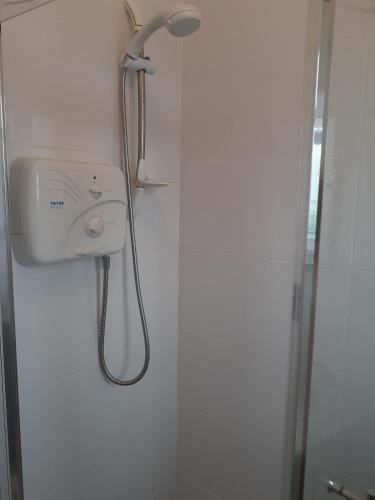 a shower in a bathroom with a shower head at Meadow View Cottage in Clooncullin Bridge