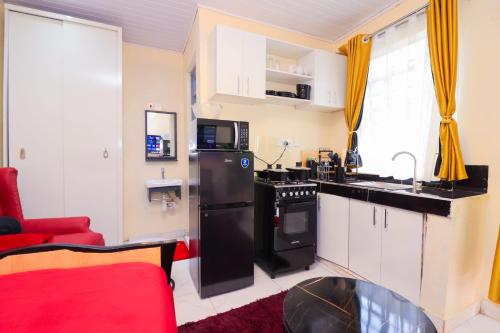 a kitchen with a black refrigerator and a red couch at The Haven in Nyeri