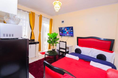 a bedroom with a red bed and a tv at The Haven in Nyeri