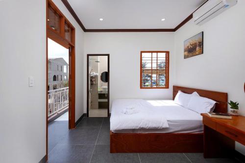 a bedroom with a bed and a view of a balcony at Homestay Hòn Đỏ Sea in Thôn Mỹ Tường